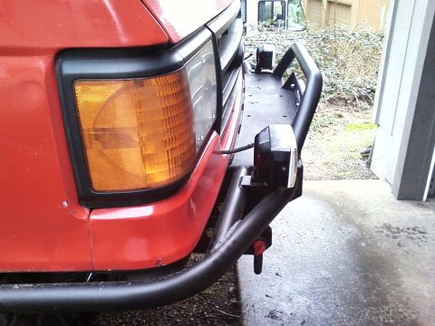 1989 Ford Bronco - Close-up of a 1989 Ford Bronco's front end, showing the turn signal and an aftermarket winch bumper.