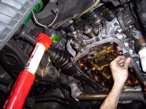1995 Ford Probe - Removing the engine oil pan to access internal components.