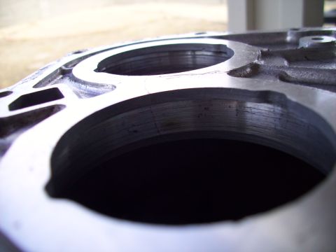 1995 Ford Probe - A close-up view of a metal engine part, showing machined surfaces and circular openings.