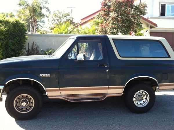 1995 Ford Bronco side view, dark green with tan trim and top