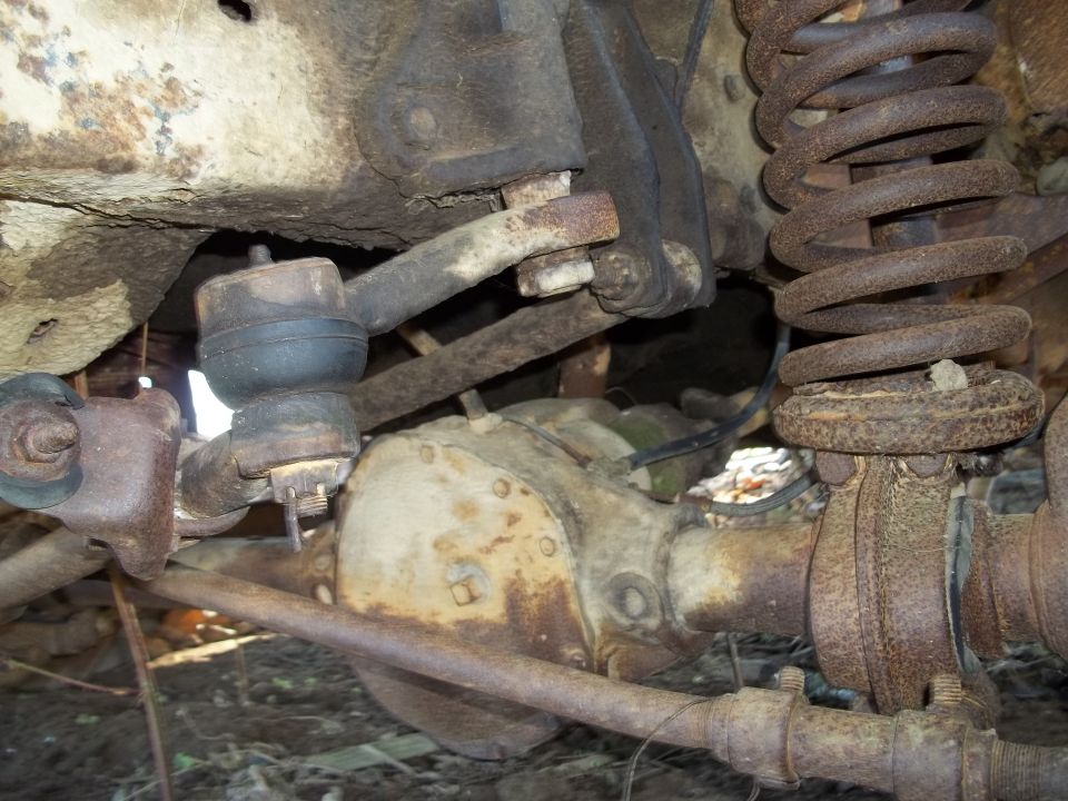 close-up of rusty truck front axle, differential, and suspension components