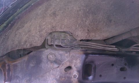 1995 Ford Bronco - Close-up view of the undercarriage, revealing brake lines and suspension parts.