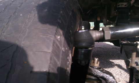 1995 Ford Bronco - A close-up view of a vehicle's tie rod end and tire tread, with "SUPERMOTORS.NET" visible at the bottom.