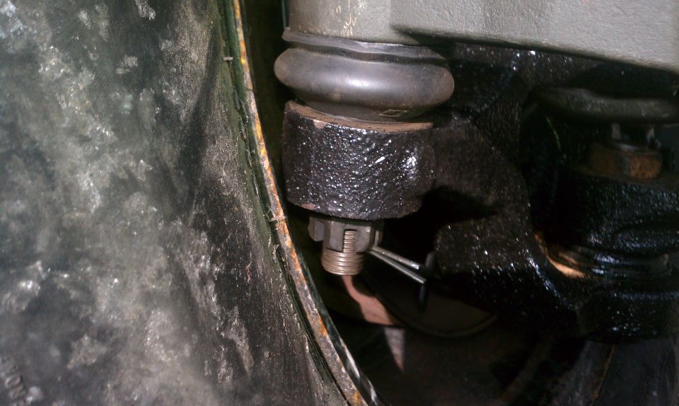 Close-up of a ball joint assembly with a cotter pin and castle nut