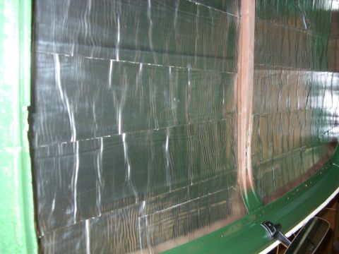 1967 Ford F-250 - Close-up of insulation being applied to a curved interior surface, possibly for sound dampening.