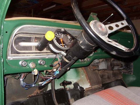 1967 Ford F-250 - The interior of a green 1967 Ford F-250 reveals a dashboard with a tachometer and various gauges.