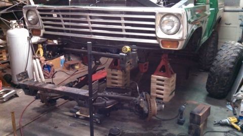 1967 Ford F-250 - This Ford truck is in a garage, raised on jack stands for maintenance, showing its front end and chassis.