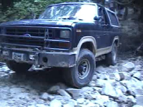1983 Ford Bronco - This dark blue Ford Bronco navigates a rocky, off-road path.