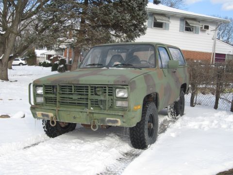 1985 Chevrolet Blazer - This 1985 Chevrolet Blazer, seen in a three-quarter front view, is covered in camouflage paint and parked in a snowy driveway.
