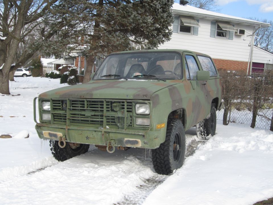 Front view of a 1985 Chevrolet Blazer in camouflage paint, parked in snow