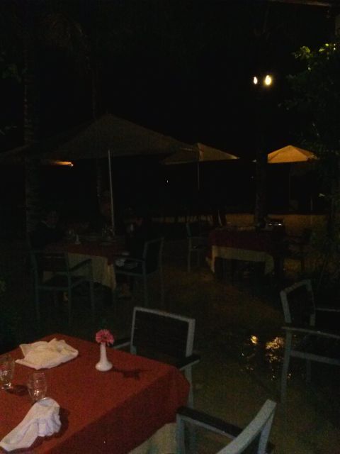 1960 Ford Falcon - An outdoor dining area is set up with tables and chairs under umbrellas at night.