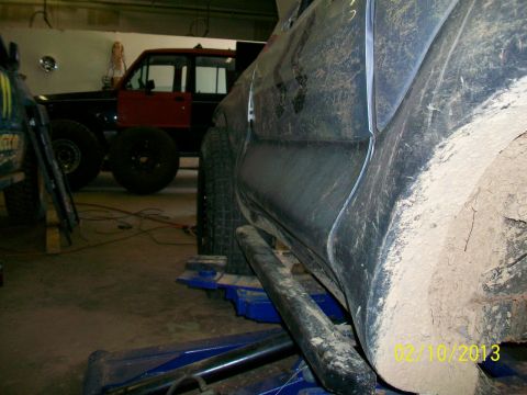 1999 Isuzu Vehicross - A vehicle is on a lift in a garage, with another vehicle visible in the background.
