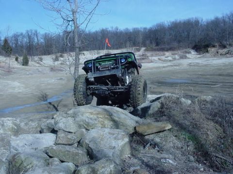 1992 Ford Bronco - An off-road SUV navigates a rocky terrain.