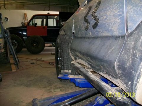 1999 Isuzu Vehicross - An SUV is being worked on in a garage, with another vehicle visible in the background.