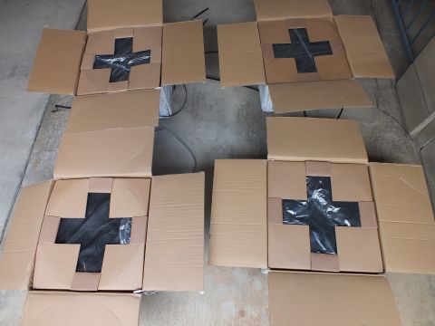 2003 Ford Crown Victoria - Overhead view of four shipping boxes, each sealed with a black tape X, arranged on a garage floor.