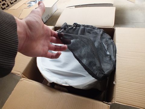 2003 Ford Crown Victoria - Black protective mesh sleeve pulled back to reveal a white-wrapped wheel packed in a carton