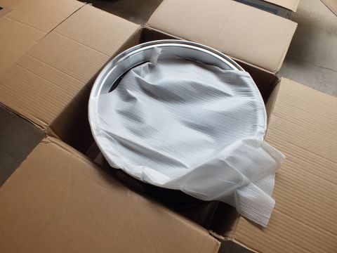 2003 Ford Crown Victoria - Alloy wheel still in white foam wrap sitting inside an open shipping carton, polished outer lip visible