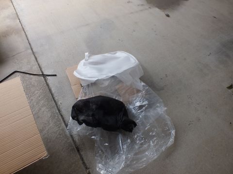 2003 Ford Crown Victoria - Black protective sleeve and white foam wheel wrap laid out on a clear plastic sheet on the floor