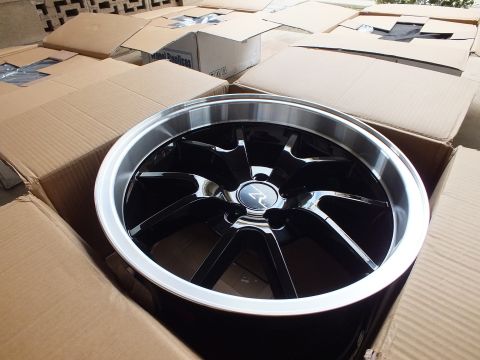 2003 Ford Crown Victoria - Black alloy wheel with polished outer lip and R-logo center cap photographed in its shipping carton