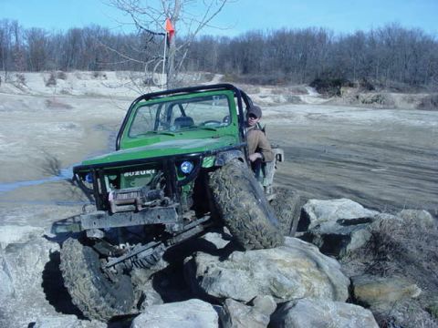 1992 Ford Bronco - A modified Suzuki Samurai navigates a rocky off-road course on a clear day.