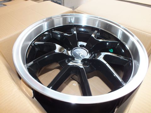 2003 Ford Crown Victoria - Black alloy wheel with polished lip, chrome center cap and a small green sticker, set in a carton