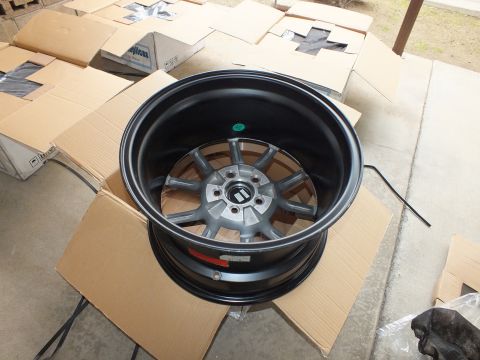 2003 Ford Crown Victoria - Deep-dish satin black wheel with gunmetal eight-spoke center lying face up in its carton