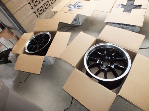 2003 Ford Crown Victoria - Two cartons each holding a black machined-lip alloy wheel among scattered packing cardboard