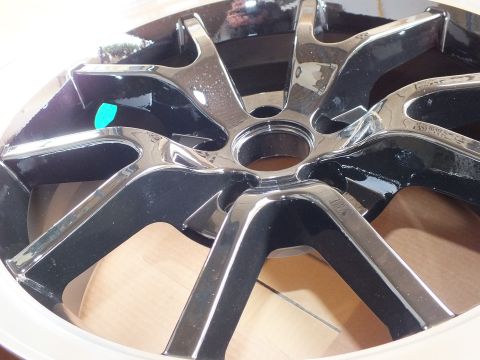 2003 Ford Crown Victoria - Tight view of shiny black and chrome wheel spokes radiating from the center hub bore