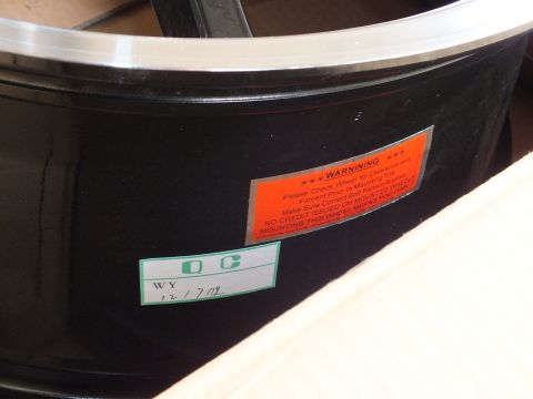 2003 Ford Crown Victoria - Inner barrel of a black wheel showing an orange warning sticker and a QC tag marked WY 12/7/19