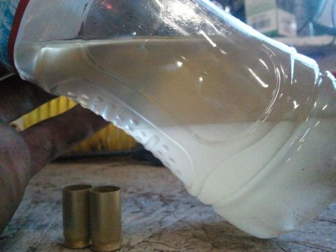 1995 Ford F-150 - A close-up shot shows two spent shell casings and a plastic bottle containing a light-colored liquid.