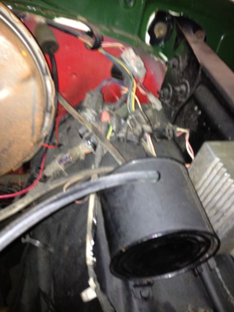 1978 Ford Bronco - Close-up of a vehicle's engine bay, showing wiring harnesses and a red firewall.