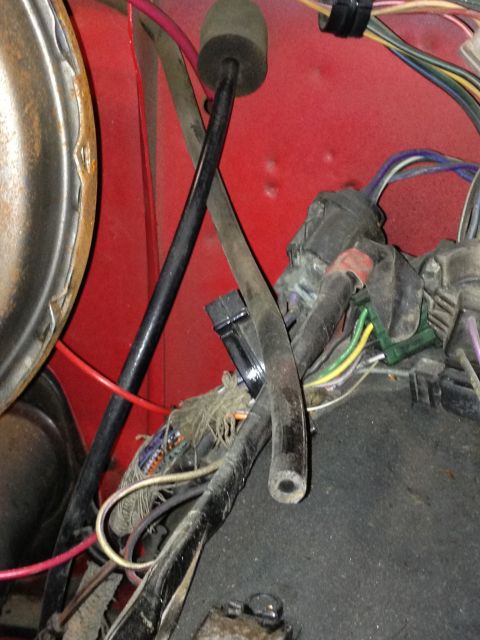1978 Ford Bronco - A view of the wiring harness and various cables within the vehicle's interior, showing a section of the red painted metal.