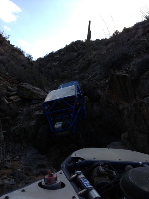1966 Ford Bronco - An off-road buggy is precariously stuck on a steep, rocky incline with another vehicle nearby.