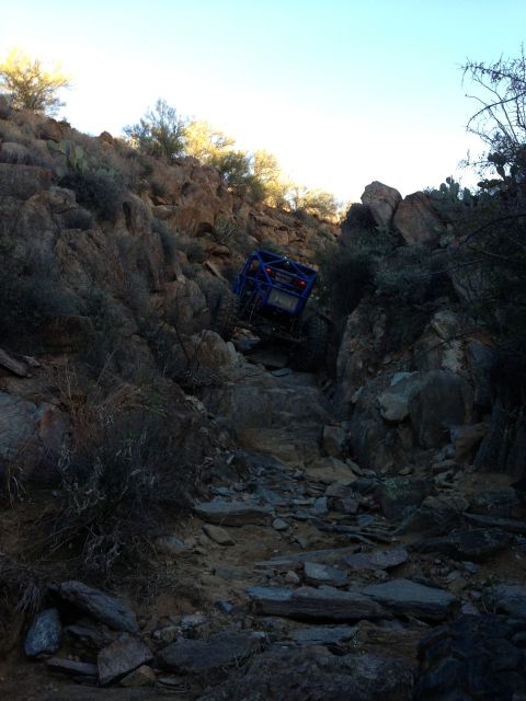 1966 Ford Bronco - A custom off-road buggy tackles a challenging rocky incline in a desert landscape.