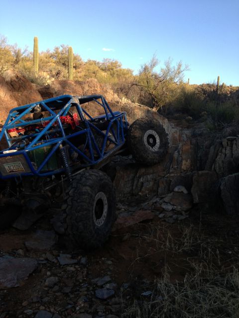 1966 Ford Bronco - A custom-built buggy navigates a rocky desert trail under a clear blue sky.