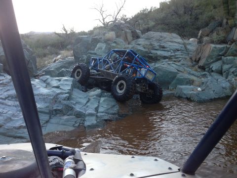 1966 Ford Bronco - A custom off-road buggy traverses a challenging rocky stream bed.