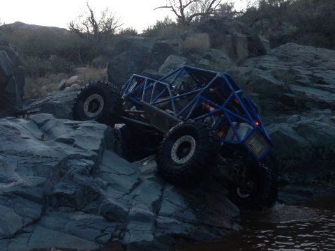 1966 Ford Bronco - This custom buggy is navigating a rocky terrain with water at its base.