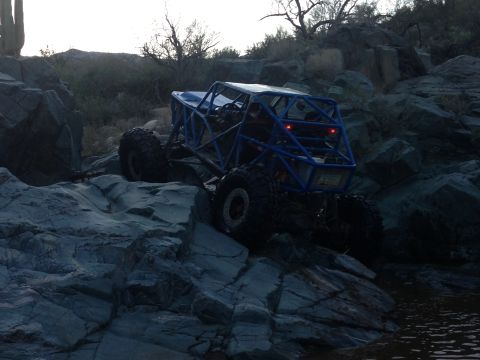 1966 Ford Bronco - A custom-built off-road buggy with a prominent roll cage is shown traversing a challenging rocky landscape.