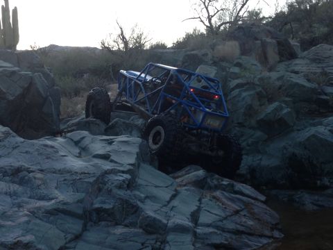 1966 Ford Bronco - Custom off-road buggy tackles a challenging rocky trail in a desert landscape.