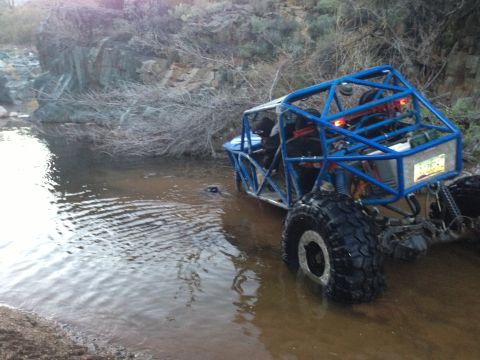 1966 Ford Bronco - Custom off-road buggy navigates a rocky stream bed.