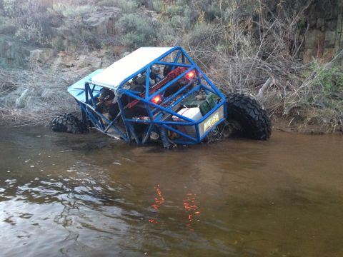 1966 Ford Bronco - This custom off-road buggy navigates through shallow, muddy water with its occupants inside.