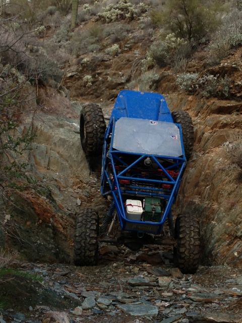 1966 Ford Bronco - Custom off-road buggy navigates a challenging rocky incline in a desert environment.