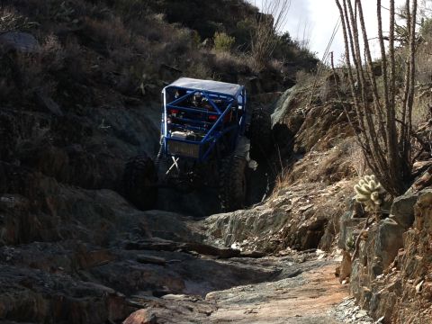 1966 Ford Bronco - Custom off-road buggy navigates a challenging rocky incline in a desert environment.