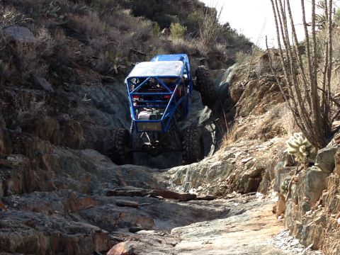1966 Ford Bronco - A custom-built off-road buggy navigates a challenging rocky terrain in a desert environment.