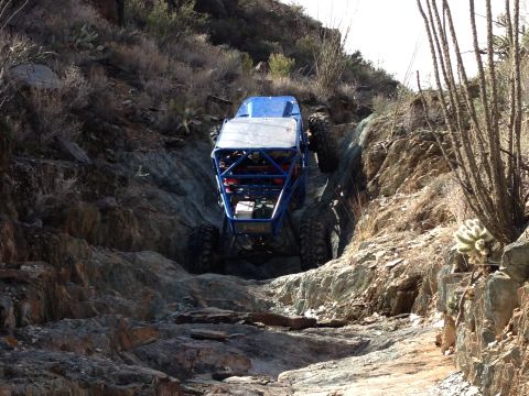 1966 Ford Bronco - A custom blue off-road buggy navigates a challenging rocky trail, its off-road capabilities.