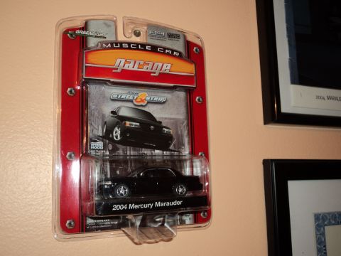 2004 Mercury Grand Marquis - Die-cast 2004 Mercury Marauder model in packaging, displayed on a wall.