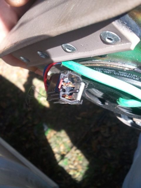 1994 Ford Bronco - Close-up of an airbag sensor connector with visible wiring and a green conduit, suggesting an interior vehicle component.