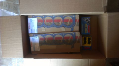 1990 Ford Bronco - A box contains engine head gaskets and other automotive parts, likely for a vehicle build.