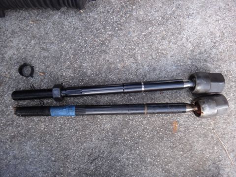 2000 Lincoln Continental - Comparison of two tie rod ends, one appearing new and the other showing signs of wear and repair with blue tape.