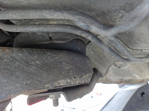 2000 Lincoln Continental - Underside view of a vehicle's suspension system, focusing on a deteriorated bushing and mounting hardware.